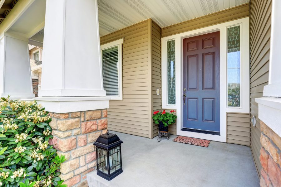 Front Entry Door With Concrete Floor Porch And Flowers Pot