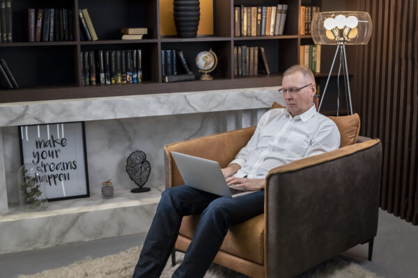 Smart Mature Businessman In Glasses Sitting In Armchair At Home